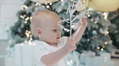 Modern evde eğlenen yakışıklı kardeşler. Balon oynayan küçük çocuk.