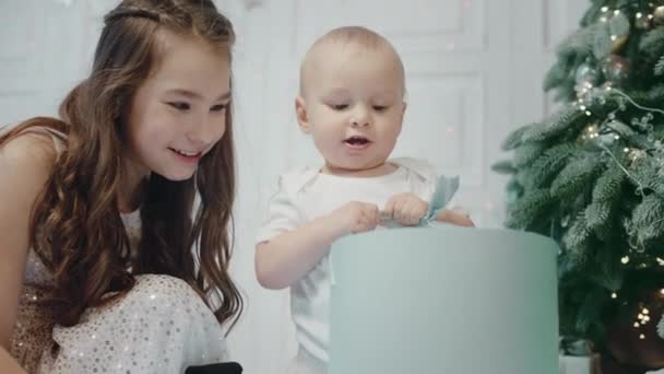 Allvarlig baby pojke hålla presentbox i modern lägenhet. — Stockvideo