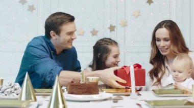 Mutlu aile birlikte lüks evde doğum günü çocuk hediye sunan.