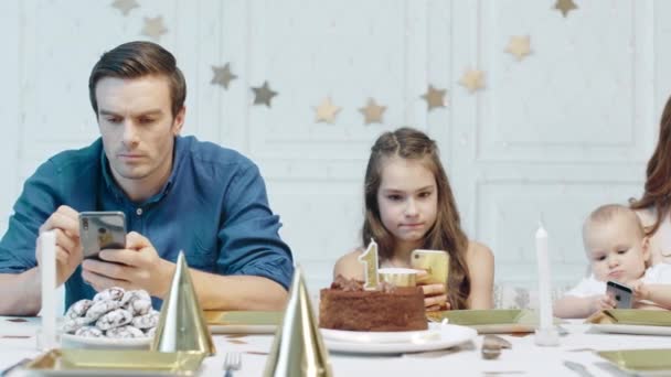 Seriózní lidé, kteří po narozeninové oslavě v luxusním domě sledují mobilní zařízení — Stock video