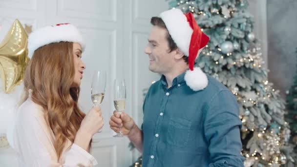 Bello uomo e donna che esprimono il desiderio sulla notte di Capodanno a cappelli di Babbo Natale insieme . — Video Stock