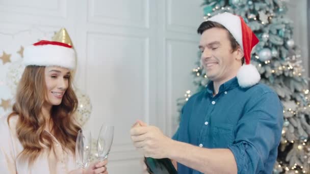 Yeni yılı köpüklü şarapla kutlayan gülen çift. — Stok video