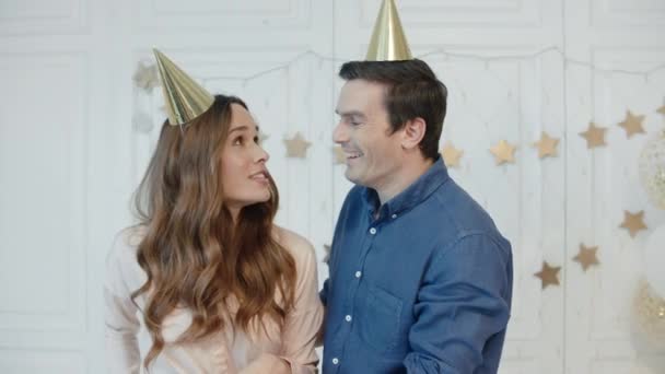 Retrato de pareja feliz haciendo selfie móvil en gorras doradas cerca del árbol de Navidad — Vídeos de Stock