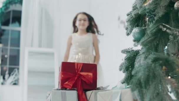 Mooi meisje op zoek cadeautjes in Nieuwjaar ingerichte kamer. — Stockvideo
