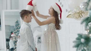 Mutlu kız kardeş ve erkek kardeşi chritmas dekore edilmiş evde birlikte sarılma.