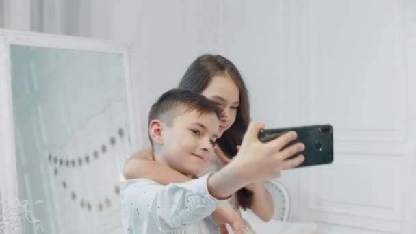 Sonriente chico y chica haciendo la diversión para selfir foto juntos . — Vídeos de Stock