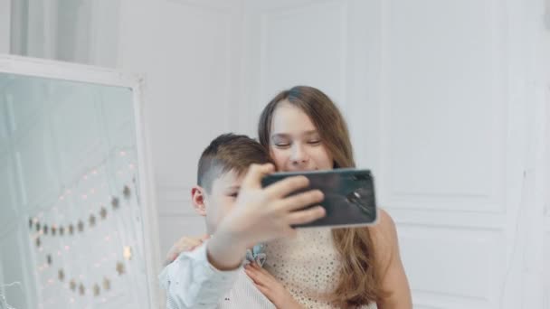 Χαμογελαστός αγόρι και κορίτσι φτιάχνοντας φωτογραφίες selfie μαζί. — Αρχείο Βίντεο