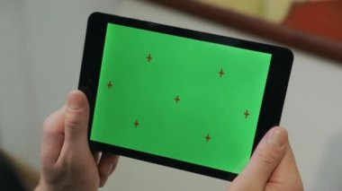 Kroma anahtar ekranı ile s tablet tutan adam. Yeşil ekranlı tablet kullanan adam