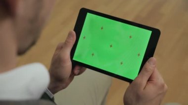 Elinde yeşil ekran olan tablet tutan adam. Tablet ekranLarını kaydıran erkek eller