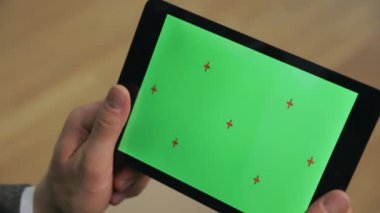 Erkek elleri yeşil ekran ile ebook tutarak. Kromanahtar ekranlı yakın çekim tablet