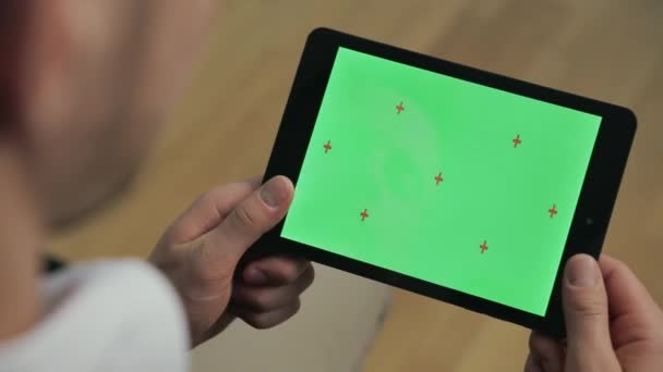 Giovane uomo in possesso di tablet pc con schermo verde. Maschio mani tiuching schermo tablet — Video Stock