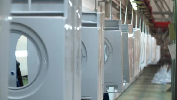 Weiße Waschmaschine, die sich auf einem Förderband bewegt. Produktion Haushaltsgeräte — Stockvideo