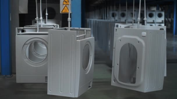 Каркас стиральной машины перемещается на автоматическом конвейере на современном заводе — стоковое видео