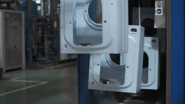 Üretim tesisinde konveyör hattı üzerinde hareket eden çamaşır makinesi gövdesi — Stok video