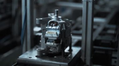 Üretim fabrikasında otomatik konveyör hattı üzerinde hareket eden metal cihaz.