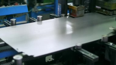 Çelik sac fabrikada üretim hattında hareket ediyor. Fabrikada metal işleme