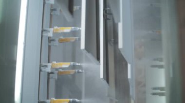 Fabrikada sprey tabancası ile metal paneller boyama. Üretim ev aletleri