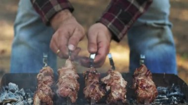 Man ızgara et barbekü açık ızgara üzerinde. Şiş kebap piknikte ızgara