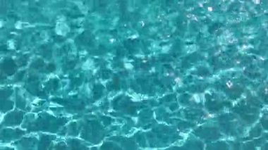 Yüzme havuzunda dalgalı su yüzeyi. Mavi su yüzeyi arka planı