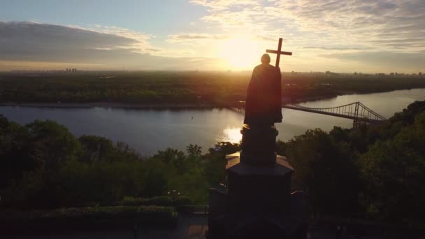 Silhouet prins Vladimir met christelijke kruis in Kiev stad op zonsondergang landschap — Stockvideo