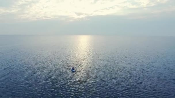 Sportsman simning kajak i havet vid solnedgången. Flygvy paddlare ridning i havet — Stockvideo