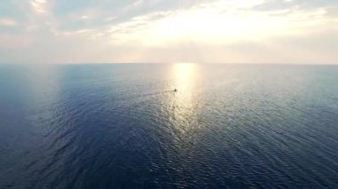 Gün batımı nda denizde kano yla kanoya balan adamlar. Kayıkta yüzen havadan görünüm kayıkçı