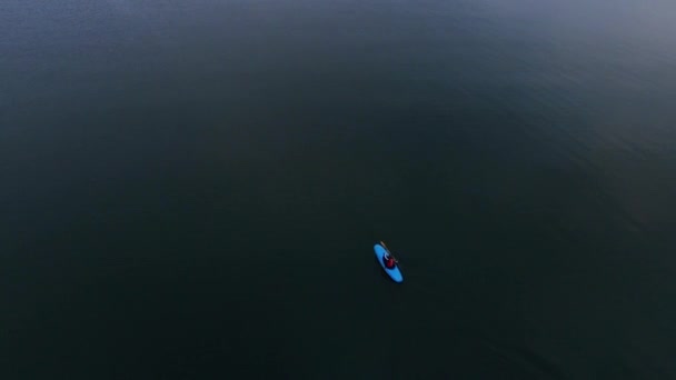Kajakfahrer schwimmt in ruhiger See. Luftbild Mann auf Kajak unterwegs auf See — Stockvideo