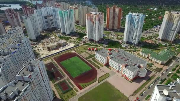 Vista aérea residencial edificio de gran altura y escuela deportiva en el patio de la escuela — Vídeo de stock