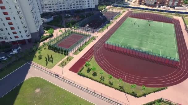 Vue aérienne enfants jouant sur le terrain de sport dans la cour quartier résidentiel — Video