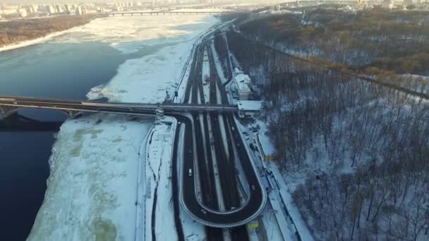 Pemandangan udara mobil mengemudi di persimpangan jalan raya di kota musim dingin. Pemandangan kota bersalju — Stok Video