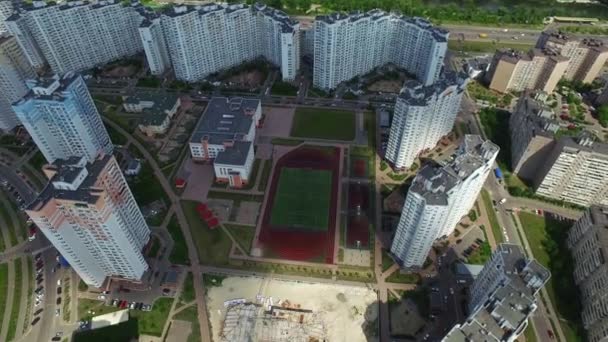 Antenn utsikt bostadsområde med hög upphov byggnad och skola sport Ground — Stockvideo