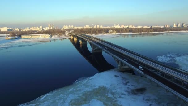 Автомобільний рух по мосту шосе в зимовому місті. Повітряний пейзаж зимового міста — стокове відео