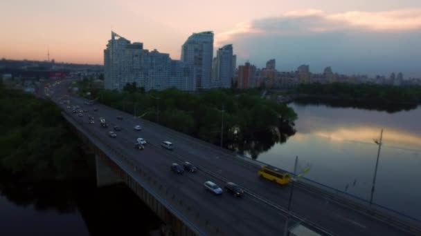 Vista aérea de la ciudad nocturna y el puente del coche. Arquitectura de la ciudad en el cielo atardecer — Vídeo de stock