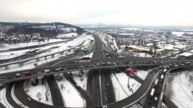 Kış şehrinde karayolu kavşağında araba trafiği. Havadan görünüm kış kavşağı