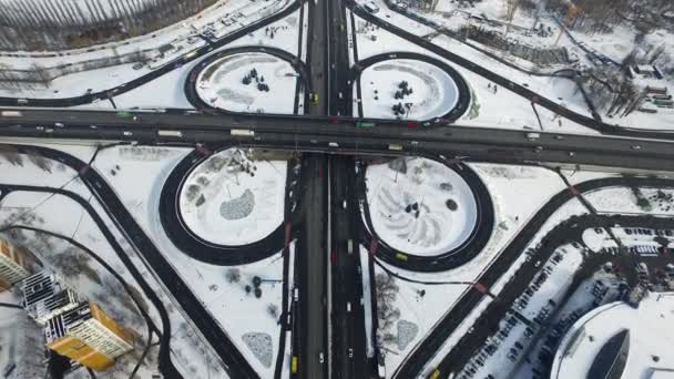 在冬季城市的公路交叉口上，无人机可观察汽车行驶。雪域城市景观 — 图库视频影像