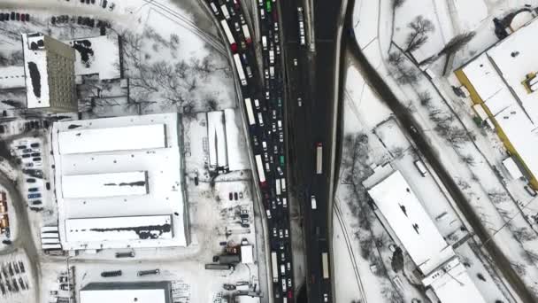 Вид сверху на автомобили, ведущие по зимнему шоссе. Снежный узел с видом на воздушное пространство — стоковое видео