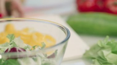 Kadın salataya taze biber ekliyor. Closeup şef kadın eller pişirme salatası