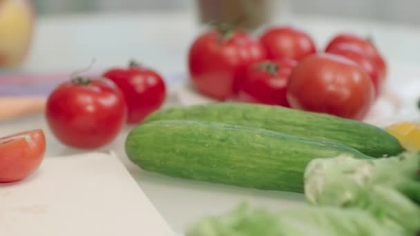 Närbild kvinnliga händer skära röda tomater med kniv. Tomater på skärbräda. — Stockvideo