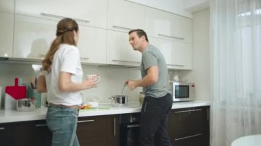Mutlu çift evde yemek yapıyor. Karı koca birlikte akşam yemeği hazırlıyor
