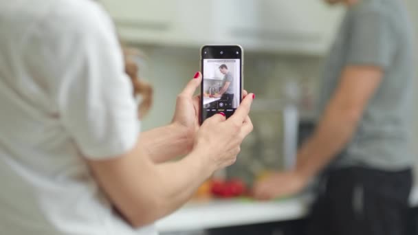 Primeros planos de las manos de la mujer tomando fotos del hombre en el teléfono móvil . — Vídeos de Stock