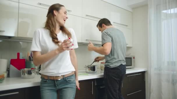 Dançando casal se divertindo enquanto cozinha comida saudável em casa . — Vídeo de Stock