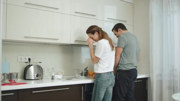 Pareja feliz cocinando juntos en casa. Hombre y mujer divirtiéndose en la cocina . — Vídeo de stock