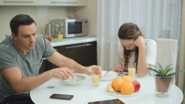 Mutlu adam kahvaltıda iyi haberler alıyor. Gülen adam evet jesti yapıyor.