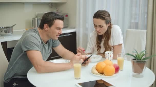 Sorrindo casal tomando café da manhã juntos na cozinha de luxo . — Vídeo de Stock