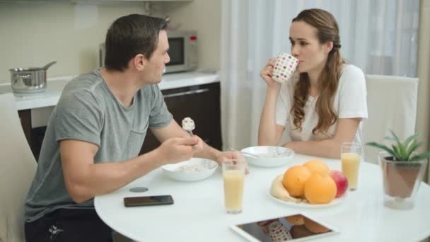 Lachend stel eet gezond ontbijt samen in een moderne keuken. — Stockvideo