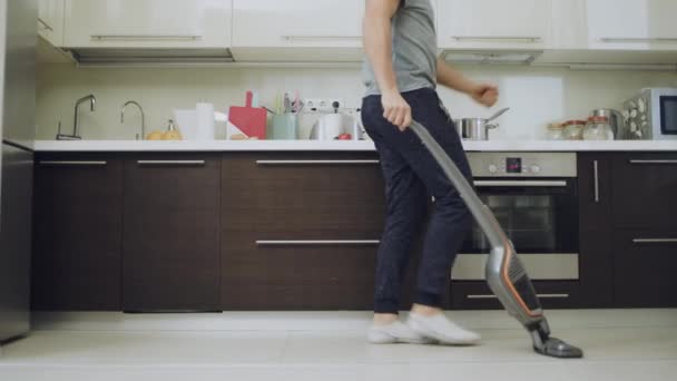 Šťastný muž uklízet podlahu dělat klikatě a s vysavačem. — Stock video