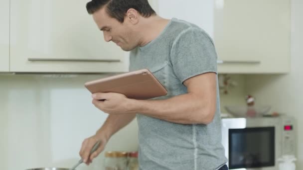 Крупный план улыбающийся мужчина готовит еду на домашней кухне . — стоковое видео