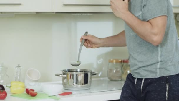 Zbliżenie szczęśliwy człowiek gotowanie zdrowe kolacja w nowoczesnej kuchni. — Wideo stockowe