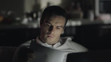 Closeup evde dizüstü bilgisayar üzerinde gece geç saatlerde çalışan adam konsantre.