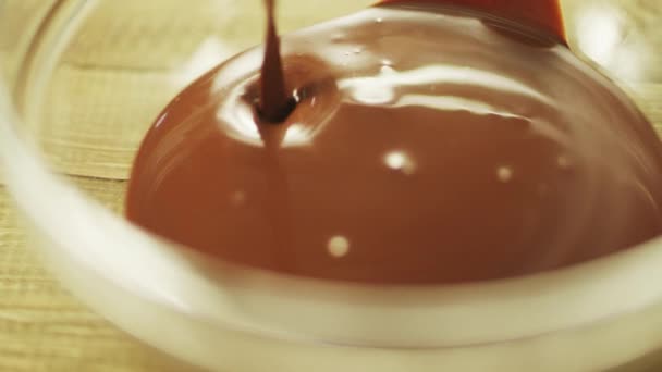 Warme chocolade gieten op glazen kom in slow motion. — Stockvideo